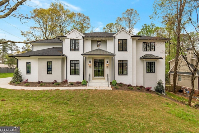 modern inspired farmhouse featuring a standing seam roof, a shingled roof, and a front lawn