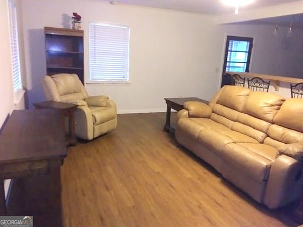 living area with baseboards and wood finished floors