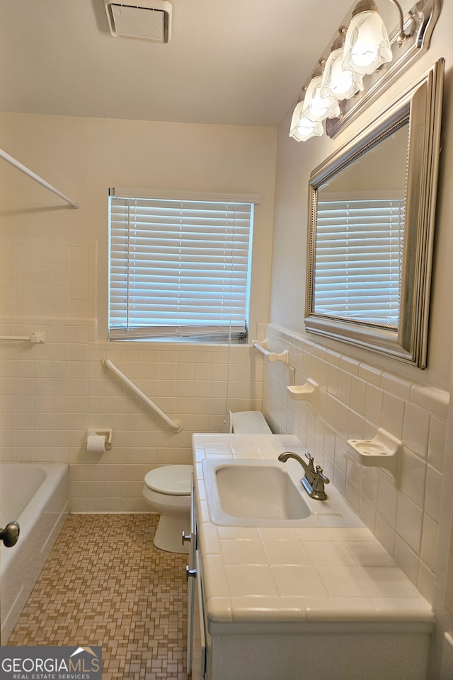 bathroom featuring vanity, visible vents, tile walls, toilet, and tile patterned floors