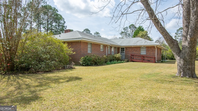 view of home's exterior featuring brick siding and a yard