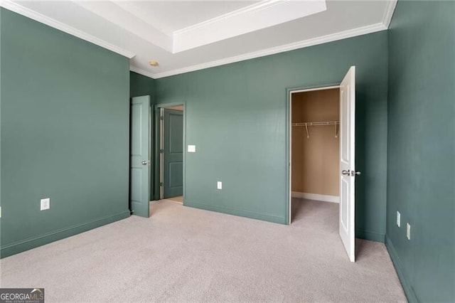 unfurnished bedroom featuring a closet, crown molding, carpet flooring, and a raised ceiling