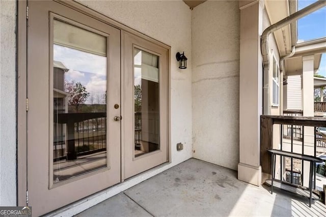 view of exterior entry featuring french doors and stucco siding