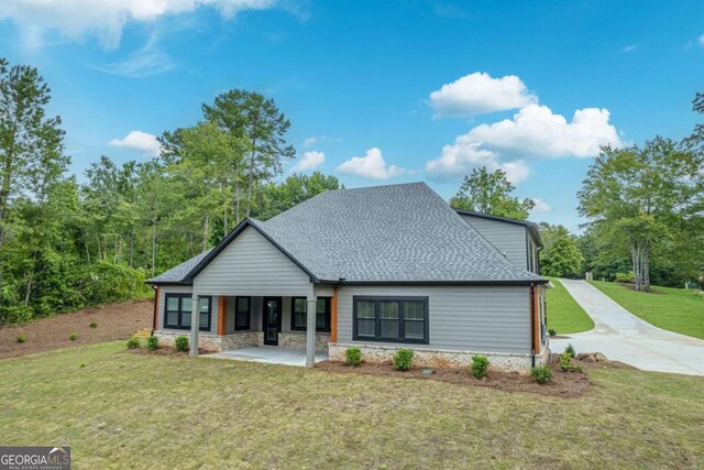 303 Tumbling Shoals Ct, Gray, GA 31032 - view of front of house with stone siding, roof with shingles, a front yard, and a patio area