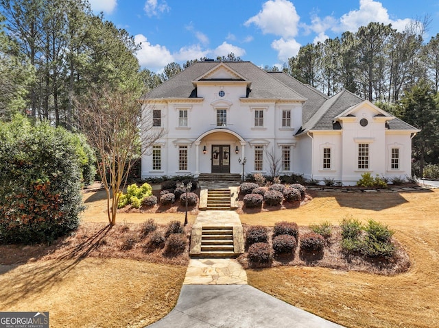 view of front of home with a shingled roof, stucco siding, and french doors