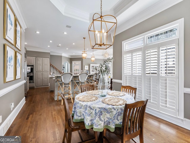dining space with dark wood-style flooring, a chandelier, crown molding, stairs, and recessed lighting