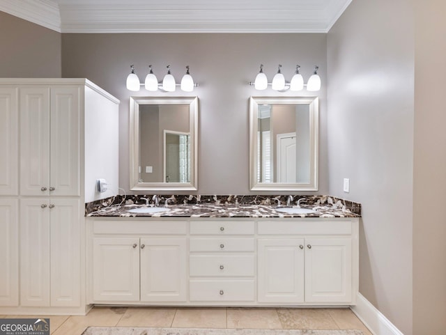 full bath featuring baseboards, double vanity, a sink, and crown molding
