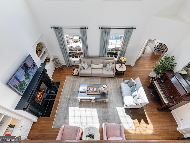 living room with a tiled fireplace and wood finished floors