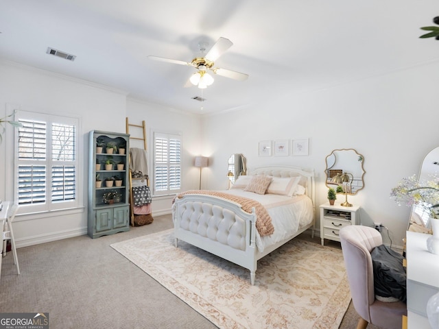 carpeted bedroom featuring baseboards, visible vents, crown molding, and a ceiling fan