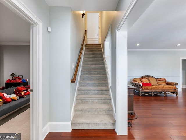 staircase featuring baseboards, recessed lighting, wood finished floors, and ornamental molding