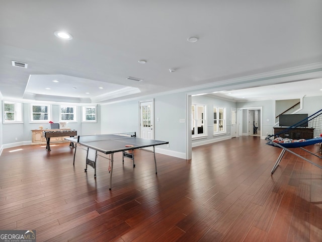 game room featuring wood finished floors, recessed lighting, a tray ceiling, and visible vents