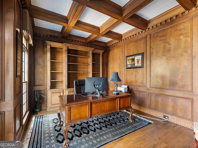 office space with dark wood-style floors, a decorative wall, coffered ceiling, and beamed ceiling