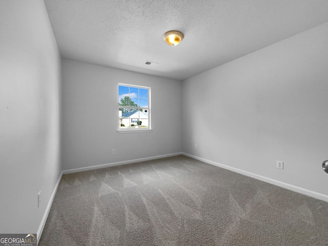 empty room featuring visible vents, baseboards, carpet, and a textured ceiling