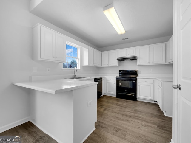 kitchen with black appliances, under cabinet range hood, a sink, a peninsula, and white cabinets