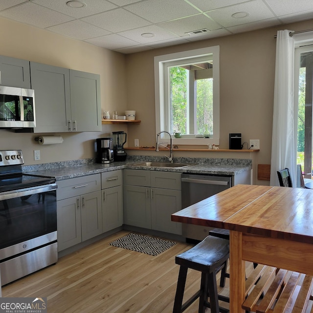 107 Oak Way Dr, Eastanollee, GA 30538 - kitchen with light wood-type flooring, gray cabinets, a sink, open shelves, and stainless steel appliances