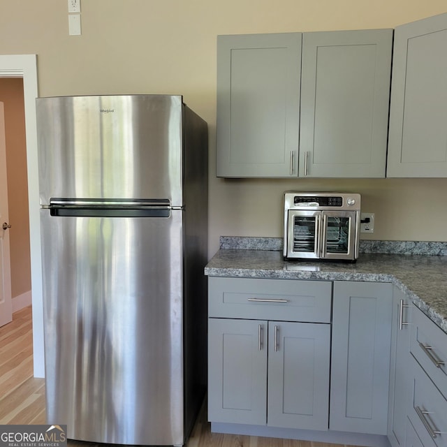 107 Oak Way Dr, Eastanollee, GA 30538 - kitchen with a toaster, gray cabinetry, light wood-style flooring, and freestanding refrigerator