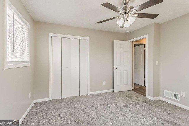 unfurnished bedroom with carpet, visible vents, and baseboards