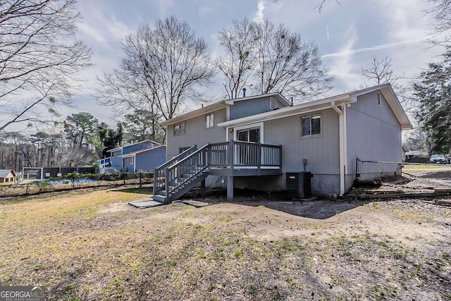 rear view of house featuring a deck, stairs, central AC, and fence