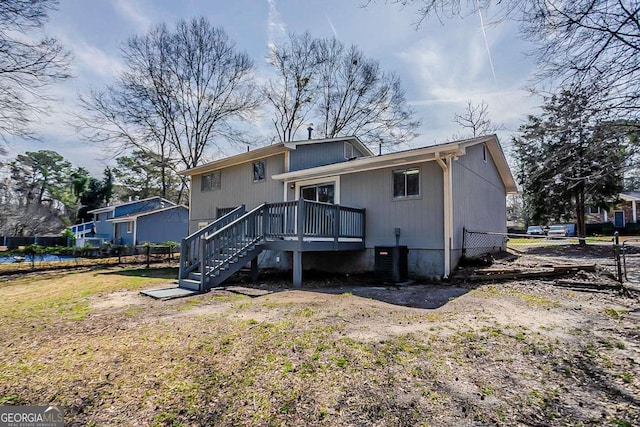 back of property with a deck, stairs, central AC, and fence
