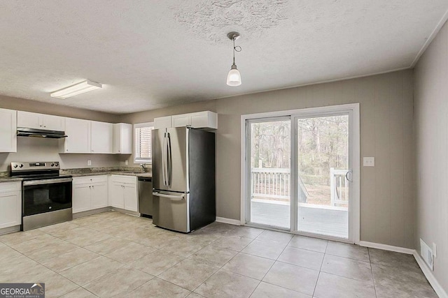 kitchen with visible vents, under cabinet range hood, appliances with stainless steel finishes, white cabinetry, and a sink