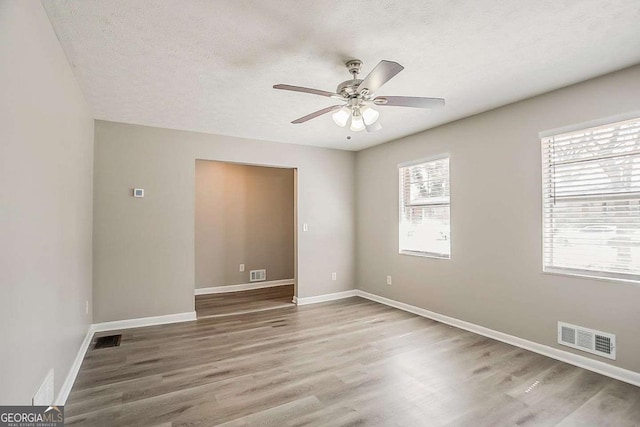 unfurnished room with visible vents and wood finished floors