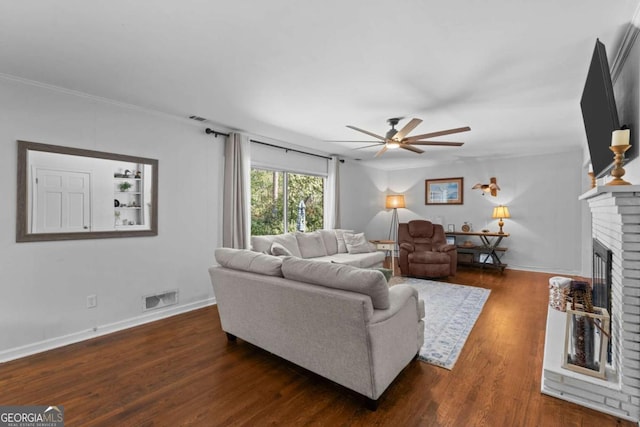 living area with a ceiling fan, visible vents, baseboards, a fireplace, and dark wood-style flooring