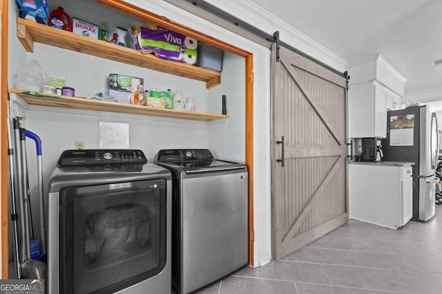 washroom with a barn door, separate washer and dryer, crown molding, light tile patterned floors, and laundry area