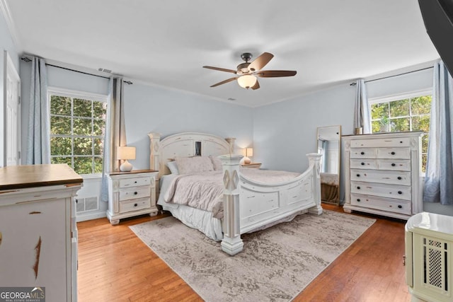 bedroom featuring a ceiling fan, multiple windows, light wood-style floors, and visible vents