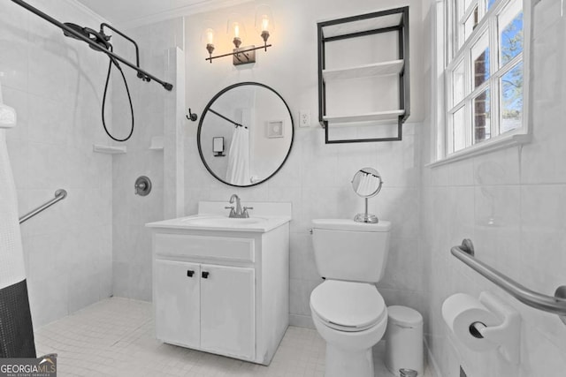 full bathroom featuring crown molding, toilet, vanity, tiled shower, and tile walls