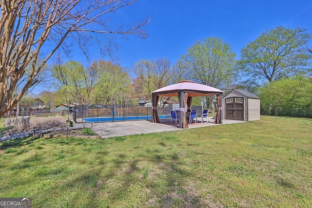 view of yard featuring a fenced backyard, an outbuilding, a storage unit, and a gazebo