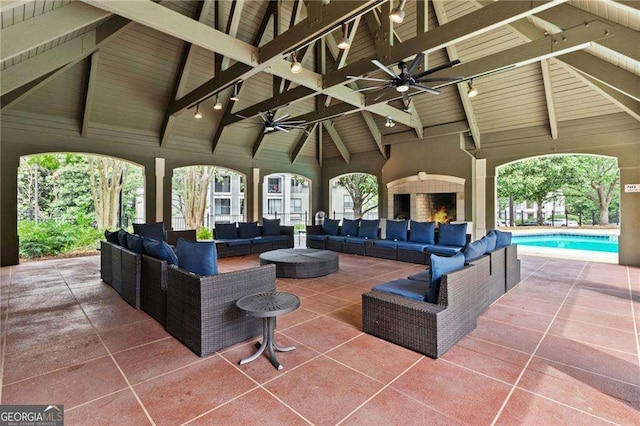 view of patio / terrace with a gazebo, an outdoor living space with a fireplace, an outdoor pool, and ceiling fan