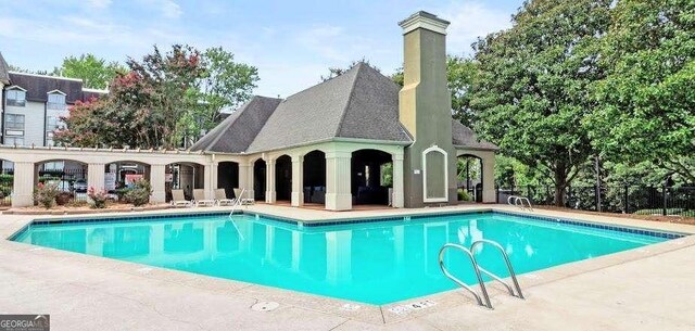 community pool featuring a patio area and fence