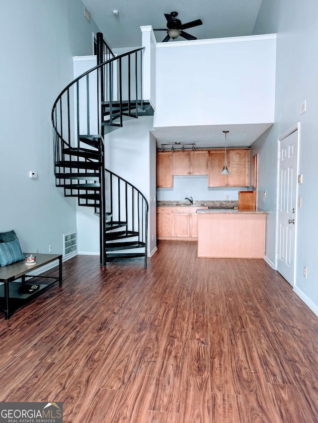interior space with dark wood-style floors, stairway, a high ceiling, and a ceiling fan