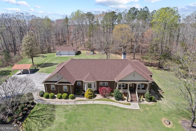 view of front of house featuring stairs, a porch, a wooded view, and a front lawn