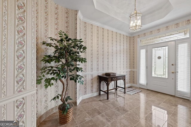 foyer featuring an inviting chandelier, wallpapered walls, crown molding, and a tray ceiling
