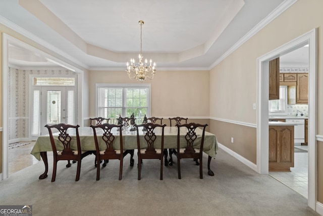 dining room with a raised ceiling, an inviting chandelier, light tile patterned floors, baseboards, and light colored carpet