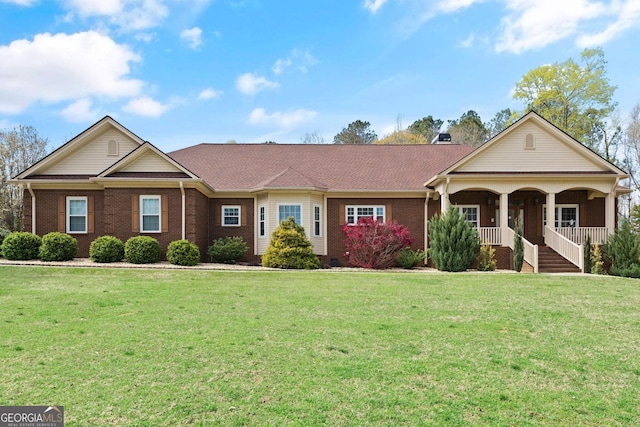 view of front of house featuring a front yard, brick siding, and covered porch