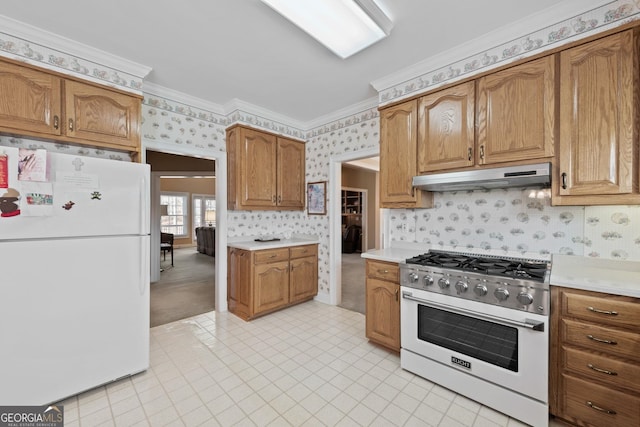 kitchen with under cabinet range hood, range with gas stovetop, freestanding refrigerator, crown molding, and wallpapered walls