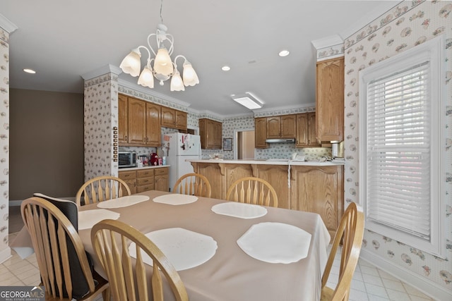 dining space featuring baseboards, wallpapered walls, recessed lighting, ornamental molding, and a chandelier