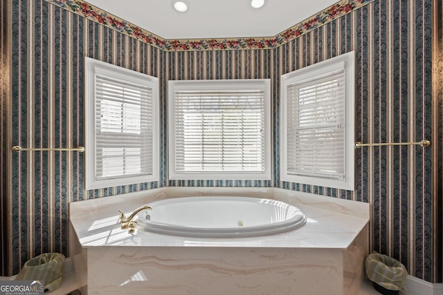 bathroom featuring a bath and wallpapered walls