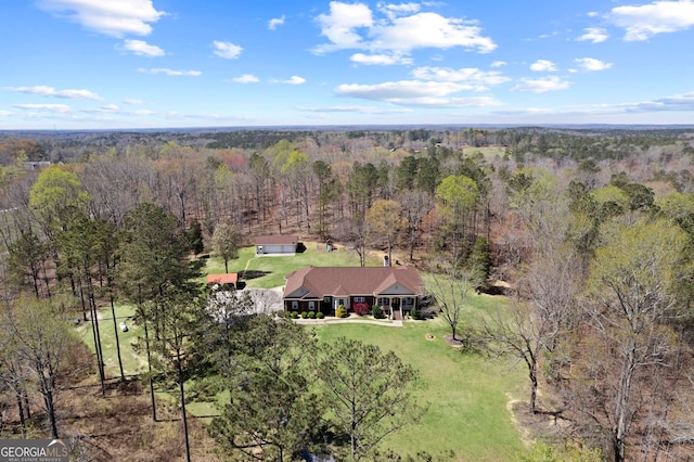 bird's eye view with a wooded view