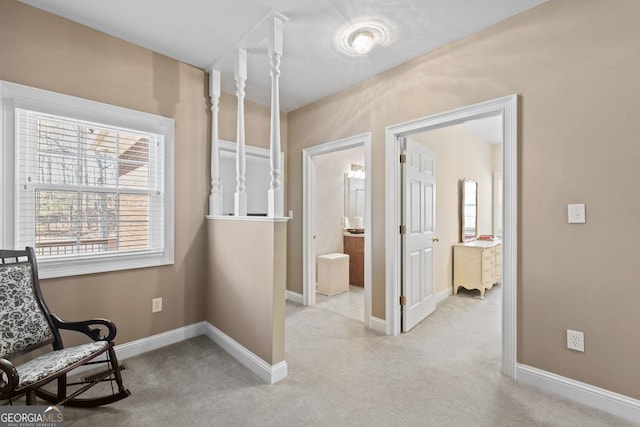 living area with baseboards and light carpet