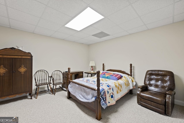 carpeted bedroom with baseboards and a paneled ceiling