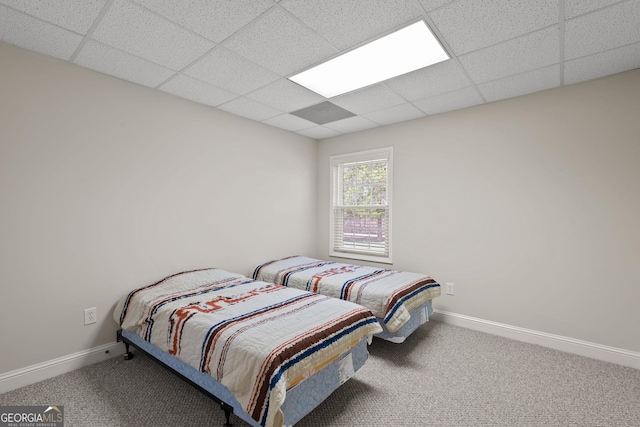 carpeted bedroom with a paneled ceiling and baseboards