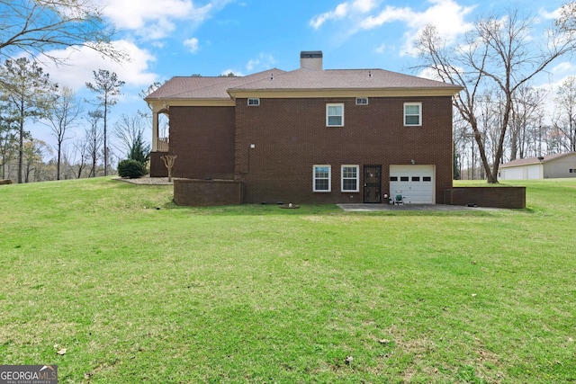 back of house featuring brick siding, a lawn, an attached garage, and a chimney