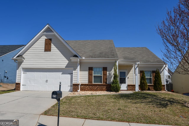 view of front of home featuring a front yard, driveway, an attached garage, a shingled roof, and brick siding