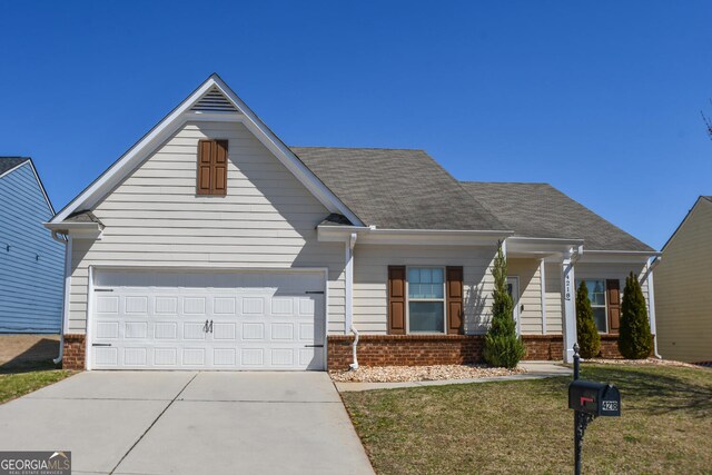 view of front of home featuring a front lawn, driveway, roof with shingles, an attached garage, and brick siding