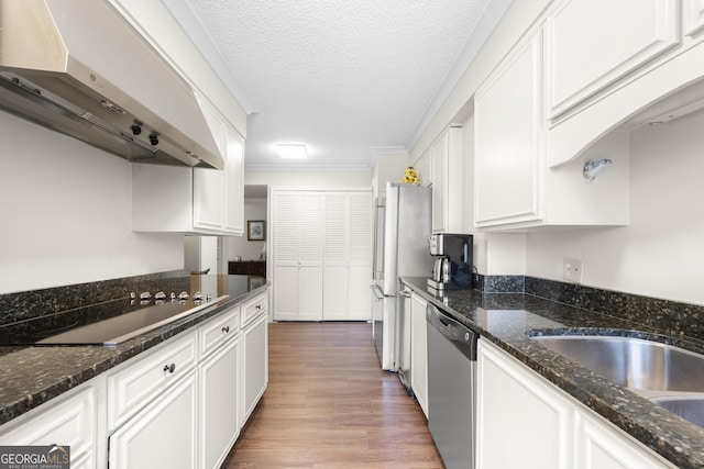 3530 Piedmont Rd NE Unit 3I, Atlanta, GA 30305 - kitchen featuring under cabinet range hood, stainless steel appliances, white cabinets, dark stone counters, and a textured ceiling