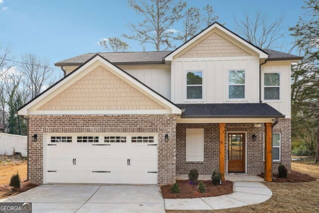 craftsman house featuring an attached garage, brick siding, and driveway