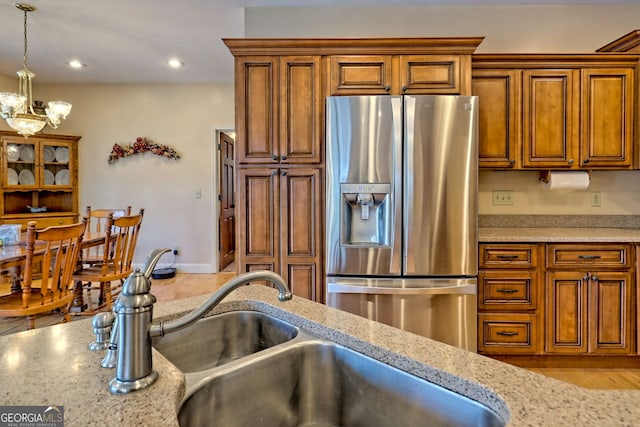 1068 Coleman River Rd, Clayton, GA 30525 - kitchen featuring stainless steel fridge with ice dispenser, brown cabinets, a chandelier, decorative light fixtures, and recessed lighting