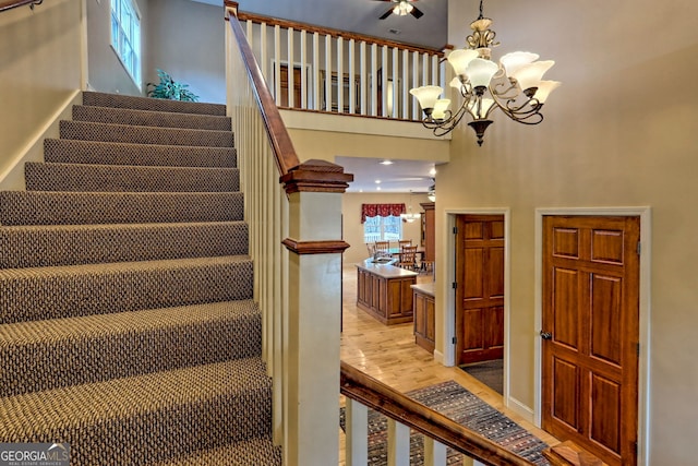 1068 Coleman River Rd, Clayton, GA 30525 - staircase with a chandelier, wood finished floors, and a high ceiling